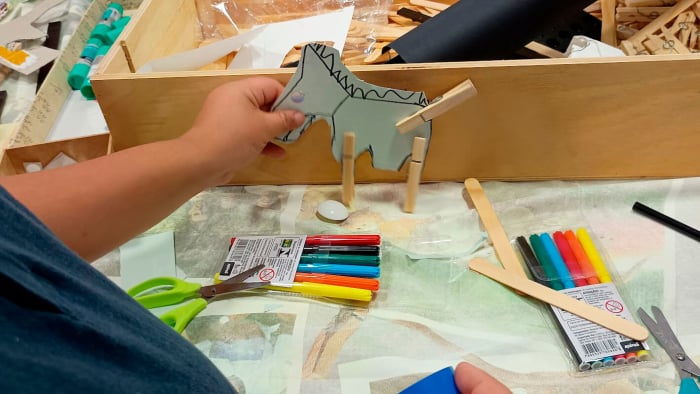 Criança construindo um brinquedo de papelão durante oficina criativa do livro O Pequeno Mundo Criativo.